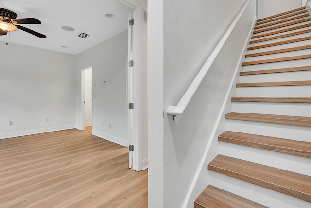 stairway with ceiling fan and light wood-type flooring