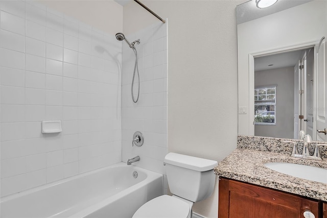 full bathroom featuring tiled shower / bath combo, vanity, and toilet