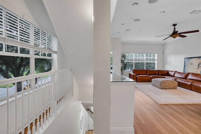 interior space featuring ornamental molding, ceiling fan, and light wood-type flooring