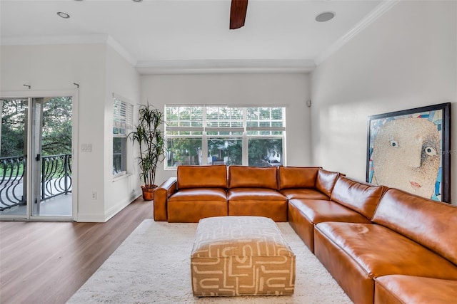 living room featuring wood-type flooring, plenty of natural light, crown molding, and ceiling fan