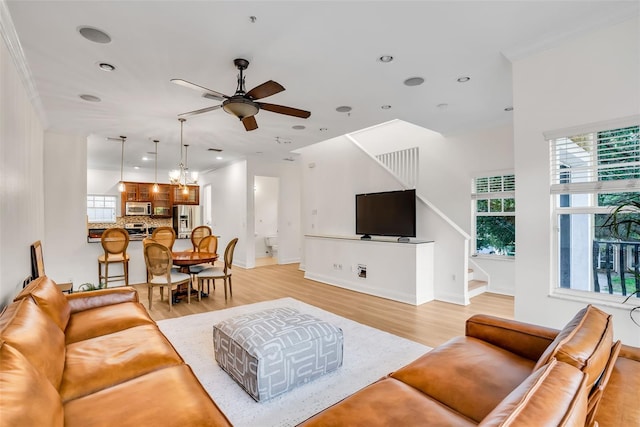 living room featuring crown molding, light hardwood / wood-style floors, and ceiling fan