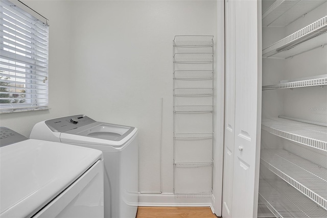 washroom with independent washer and dryer and light hardwood / wood-style flooring