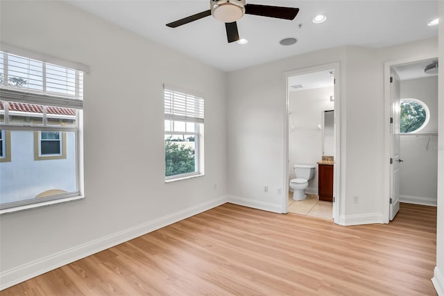 unfurnished bedroom featuring ensuite bath, light hardwood / wood-style flooring, and ceiling fan