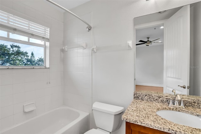 full bathroom featuring tiled shower / bath, toilet, ceiling fan, and vanity