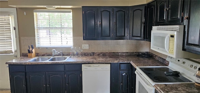 kitchen featuring a sink, decorative backsplash, white appliances, and dark countertops