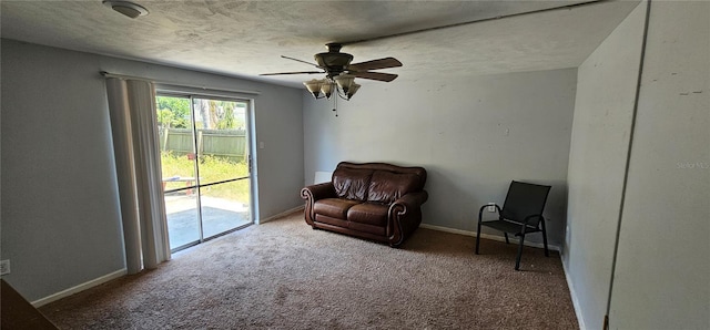 sitting room with baseboards, carpet, a ceiling fan, and a textured ceiling