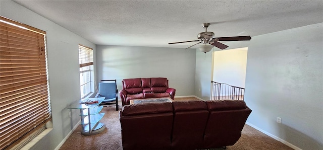 carpeted living area featuring baseboards, a textured ceiling, and ceiling fan