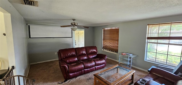 living room with baseboards, visible vents, a wealth of natural light, and a textured ceiling