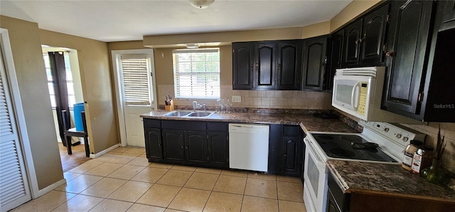 kitchen featuring a sink, white appliances, dark countertops, and dark cabinets