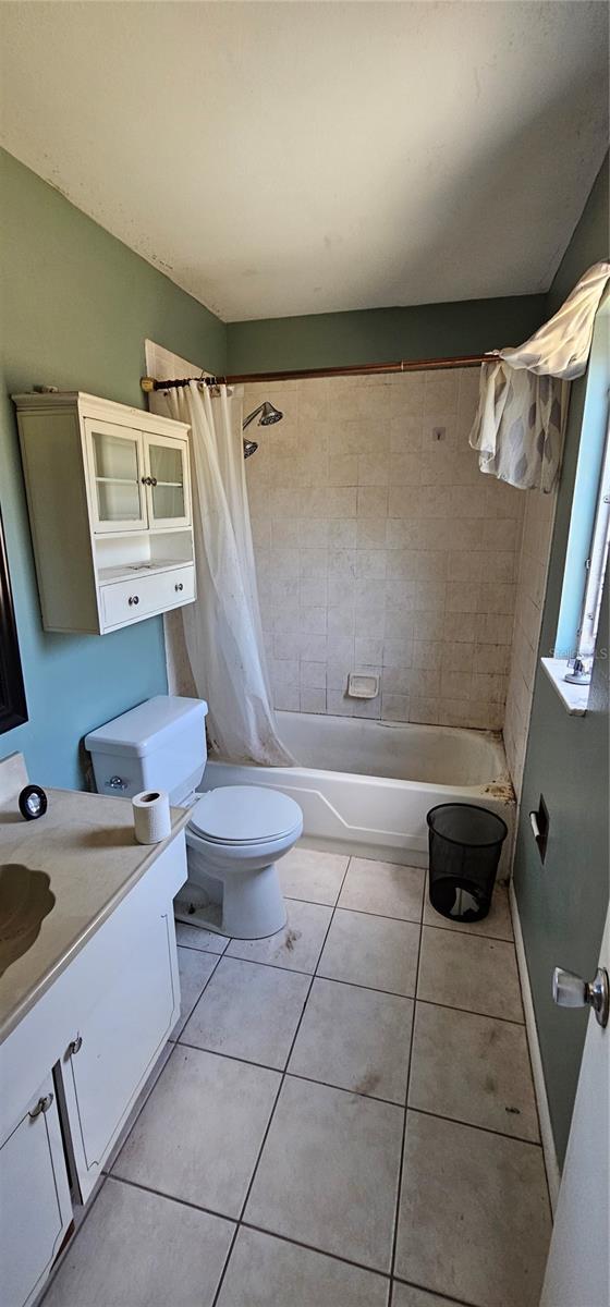 bathroom with tile patterned flooring, toilet, vanity, and shower / bath combo