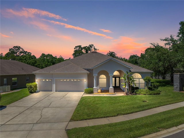 view of front of home featuring a garage and a lawn