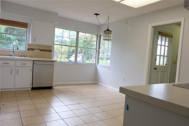 kitchen featuring hanging light fixtures, stainless steel dishwasher, white cabinets, sink, and tasteful backsplash