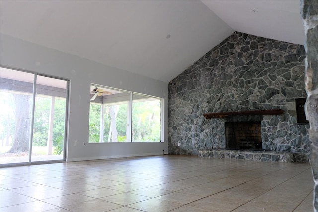 unfurnished living room featuring plenty of natural light, tile flooring, a fireplace, and lofted ceiling