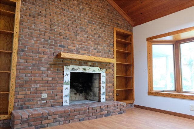 unfurnished living room with brick wall, vaulted ceiling, light wood-type flooring, and a fireplace