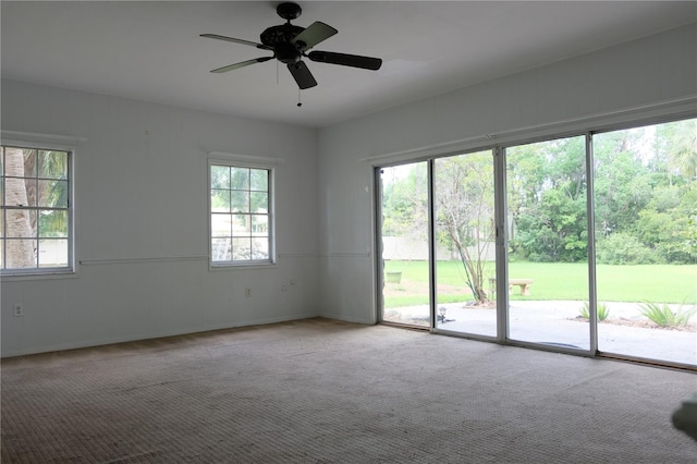 carpeted spare room featuring plenty of natural light and ceiling fan