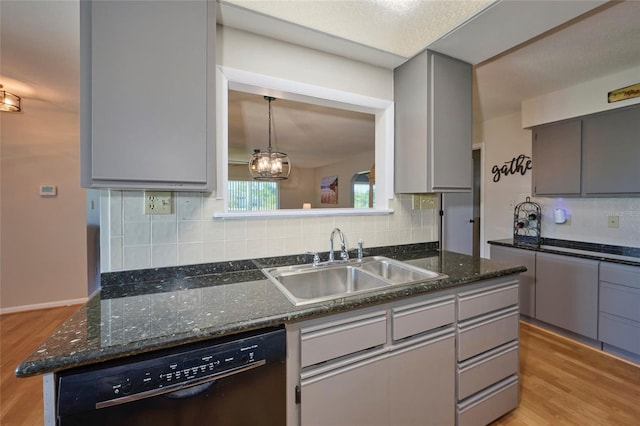 kitchen featuring black dishwasher, tasteful backsplash, sink, and light wood-type flooring