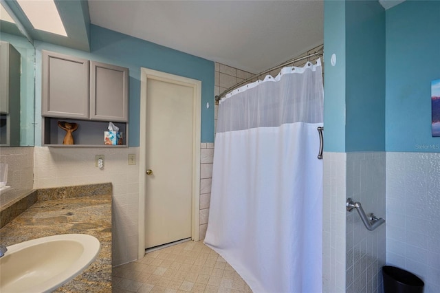 bathroom with tile floors, tile walls, and large vanity