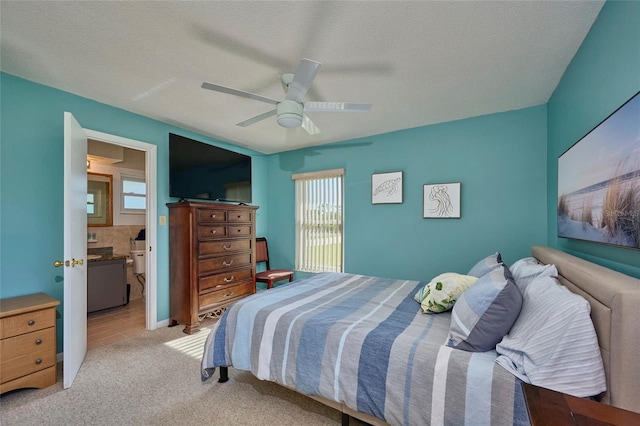 carpeted bedroom with connected bathroom, multiple windows, ceiling fan, and a textured ceiling