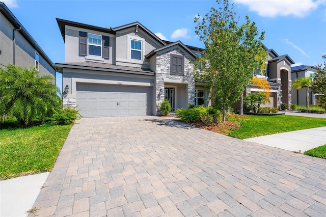 view of front of property with a garage, stone siding, decorative driveway, and stucco siding