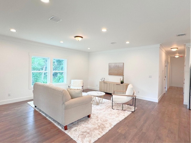 living room featuring dark hardwood / wood-style floors and ornamental molding