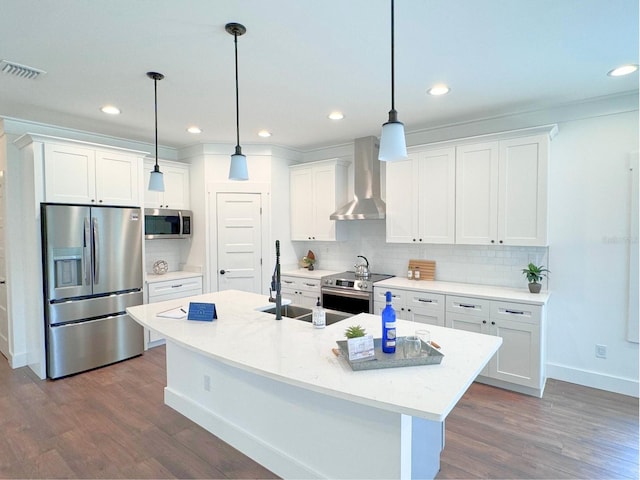 kitchen featuring dark wood-type flooring, stainless steel appliances, a kitchen island with sink, wall chimney exhaust hood, and tasteful backsplash