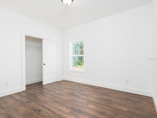 unfurnished bedroom with dark hardwood / wood-style flooring and a closet