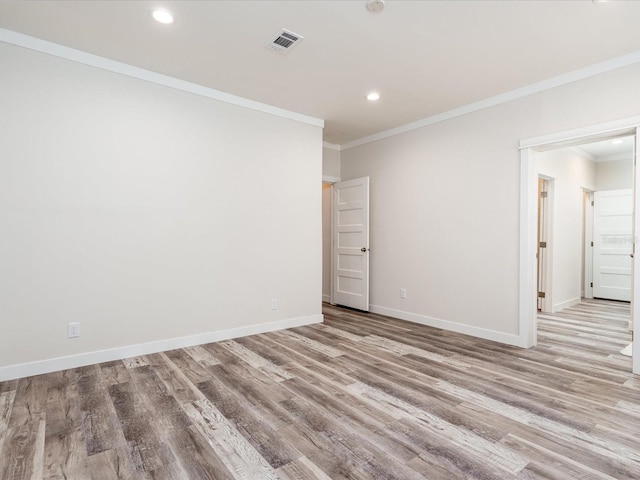 empty room featuring ornamental molding and wood-type flooring