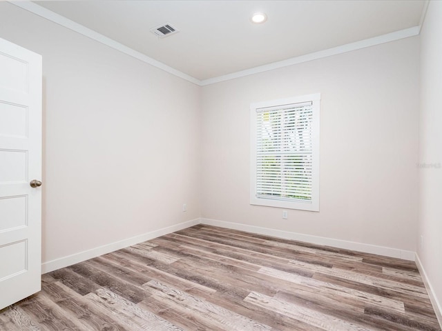 unfurnished room with hardwood / wood-style floors and crown molding