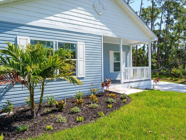 view of home's exterior featuring covered porch and a yard