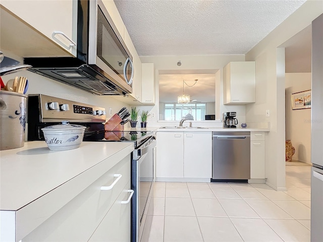 kitchen with white cabinets, sink, appliances with stainless steel finishes, and light tile flooring