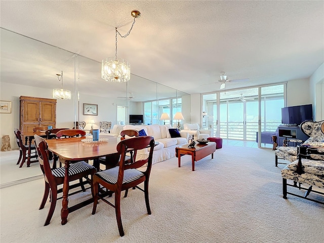 dining area with light carpet, a wall of windows, ceiling fan with notable chandelier, and a textured ceiling