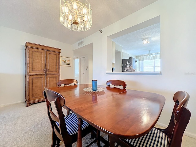 carpeted dining area featuring a chandelier and a textured ceiling