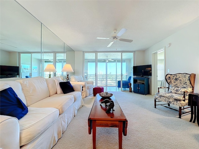 carpeted living room featuring ceiling fan and expansive windows