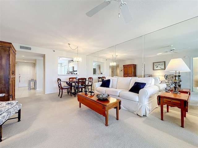 living room featuring light carpet and ceiling fan with notable chandelier