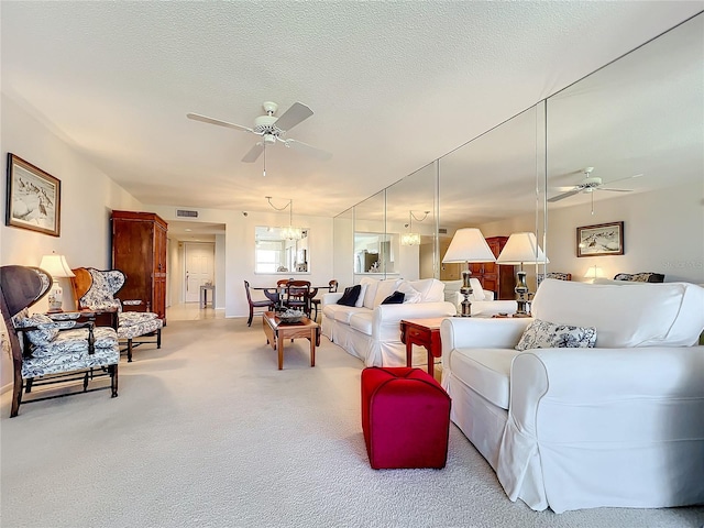 living room with light carpet, ceiling fan, and a textured ceiling