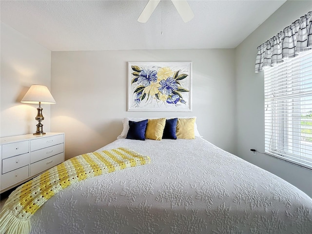 bedroom with ceiling fan and a textured ceiling