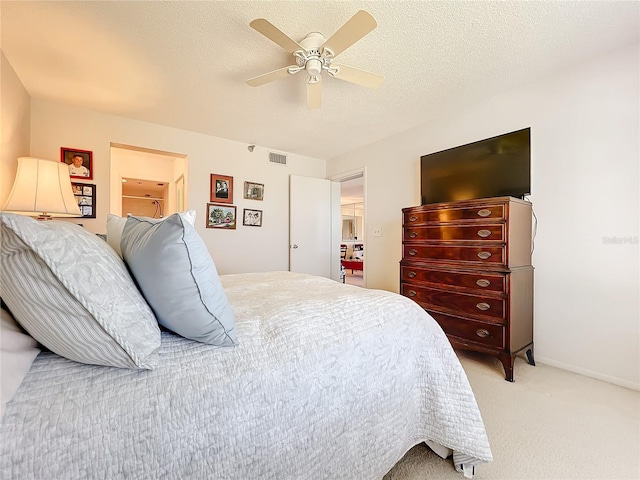 bedroom with light carpet, ceiling fan, and a textured ceiling