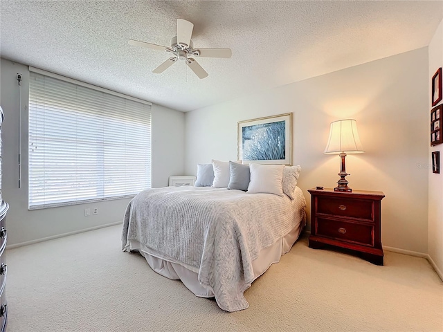 carpeted bedroom with ceiling fan and a textured ceiling