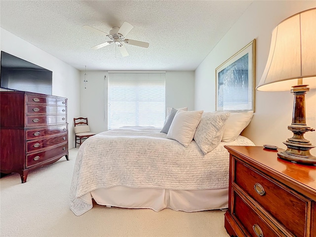 carpeted bedroom with a textured ceiling and ceiling fan