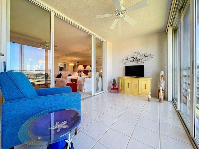 tiled living room with ceiling fan and a textured ceiling