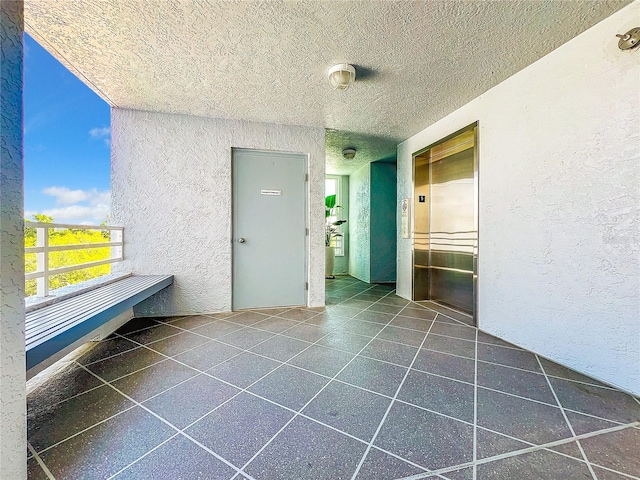 interior space featuring dark tile floors and a textured ceiling