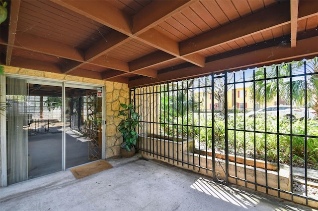 unfurnished sunroom featuring beamed ceiling