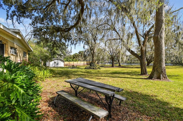 view of home's community featuring a lawn and a shed