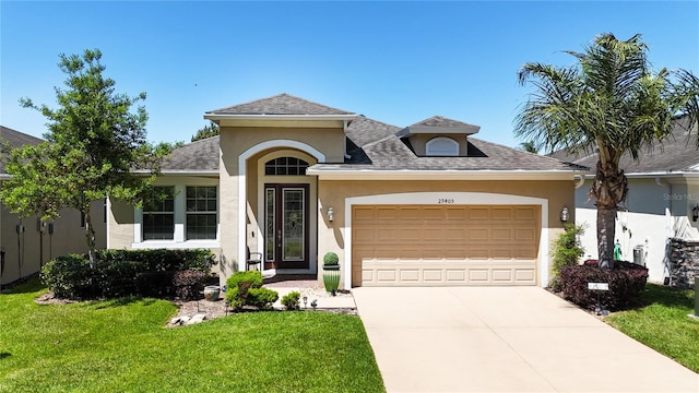 view of front of property with a garage and a front lawn