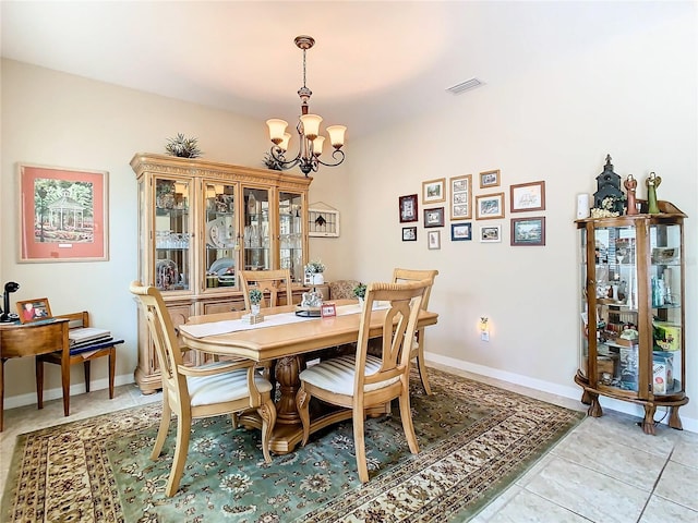 tiled dining room with an inviting chandelier