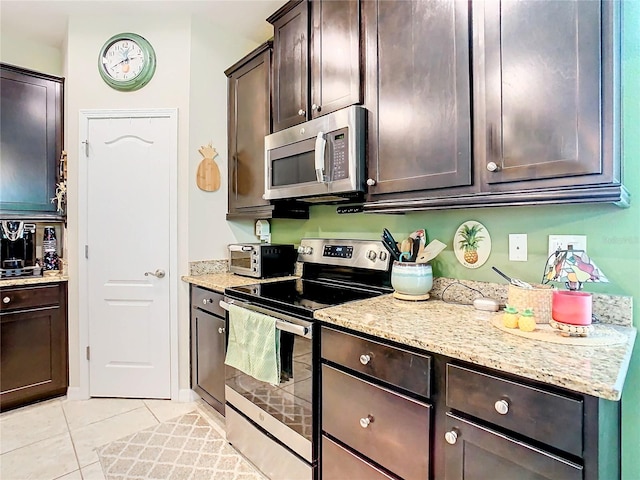 kitchen featuring appliances with stainless steel finishes, dark brown cabinetry, and light tile flooring