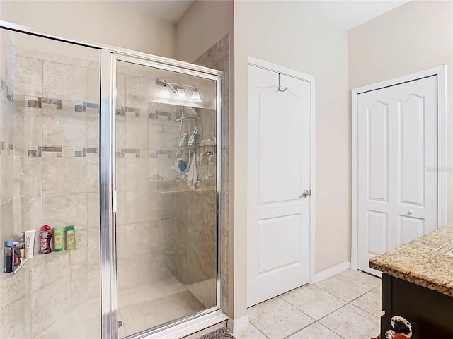 bathroom featuring tile floors, vanity, and a shower with door