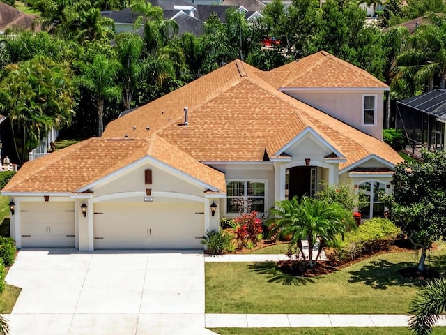 mediterranean / spanish-style home featuring a garage and a front lawn