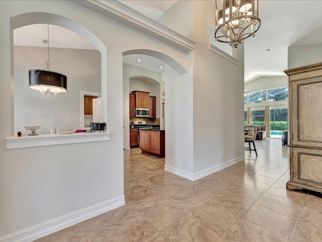 hall with vaulted ceiling, light tile flooring, and an inviting chandelier