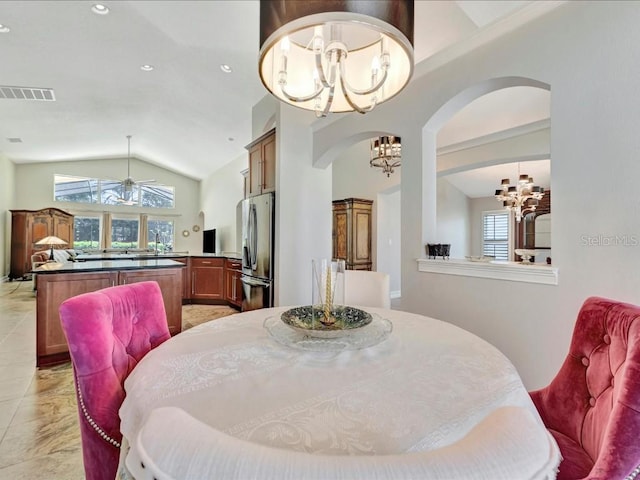 tiled dining space with lofted ceiling, a chandelier, and sink